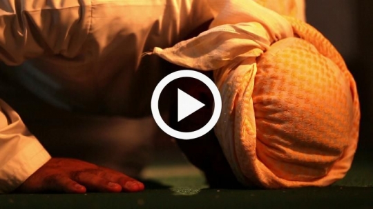 Close-up of old man praying at the mosque