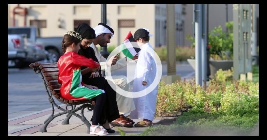 Arabian family sitting on the bench celebrating the UAE National Day|