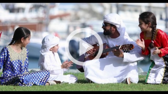 Arab family sitting on the grass celebrating the UAE National Day|