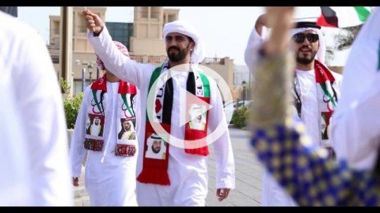Arab family during a National Day parade celebrating their country|