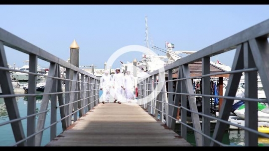 Three arab friends walking on the dock talking to each other|