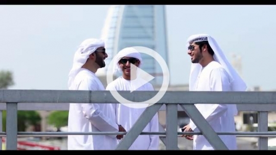 Emirati men standing by the dock talking to each other|