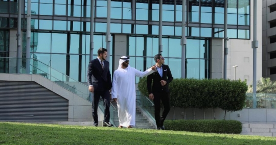 Businessmen walking together outside|-