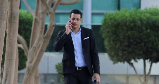 Arab Businessman walking talking on the phone|-