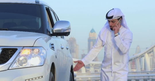 Middle Eastern Businessman looking at the car tire|-