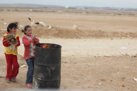 two girls burning cardboard in a fire