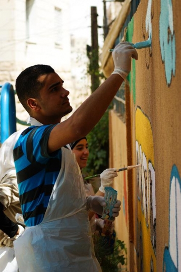 group of volunteer drawing on the wall of kindergarten