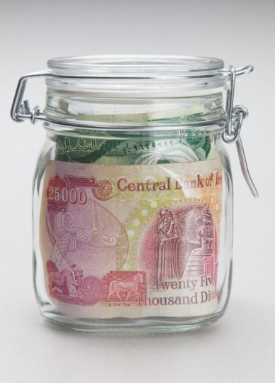 glass jar filled of iraqi dinar notes