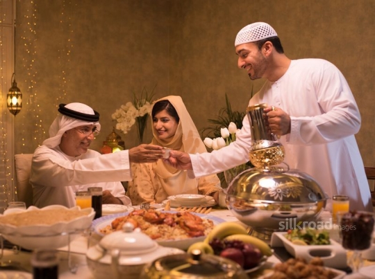 Man serving grandfather Arabic coffee|-