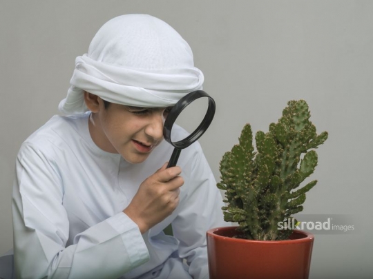 Arabian boy looking through his magnifier