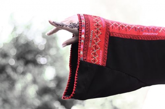 muslim lady hand being decorated with henna tattoo