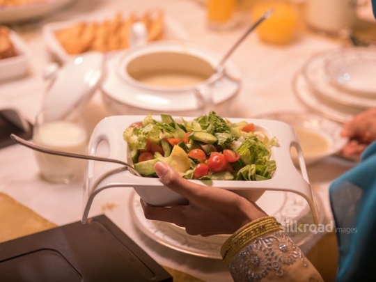 Woman serving salad|-