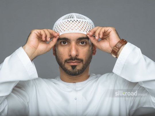 Arabian man fitting his traditional hat