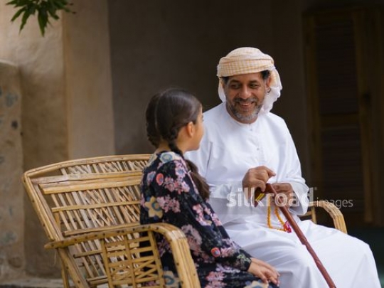 Old man sitting with granddaughter|-