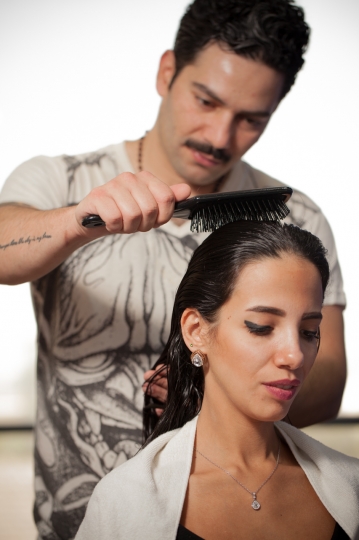 Hairdresser brushing the customers wet hair|