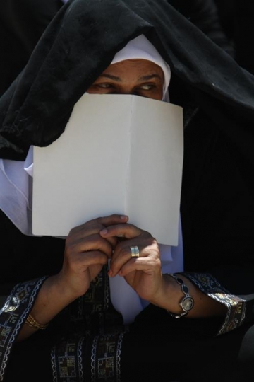 muslim woman putting sheet on her face