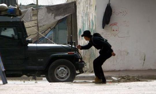 israeli police vehicle with palesinian young man
