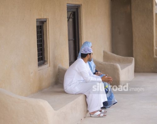 Arabic couple sitting outside|-