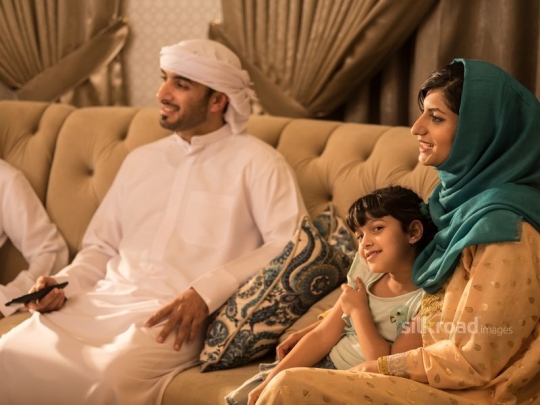 Couple with daughter watching TV|-