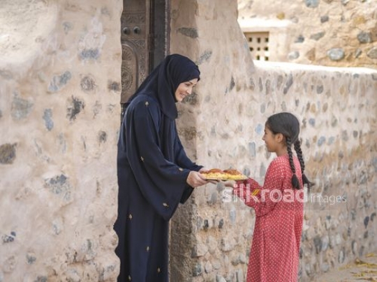 Woman receiving meal from little girl|-