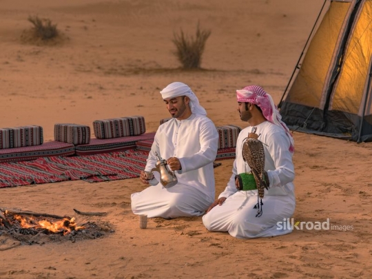 Friends seated outside tent