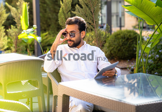 Arab Man Enjoying Coffee While Working Outdoors in Jordan