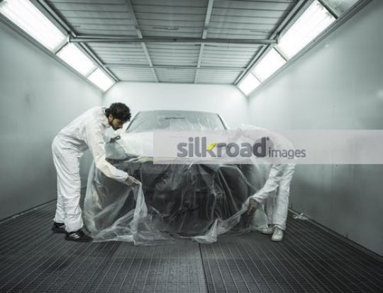 Engineers wrapping the car with paper|