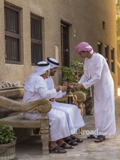 Arab son offering dates to his grandfather and father|-