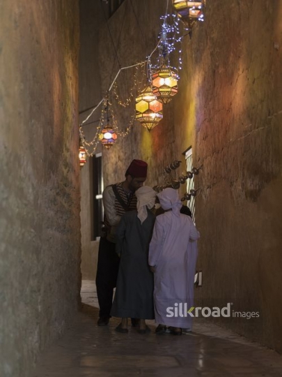 A Middle Eastern Ramadan drink seller offering the young boys some juice|-