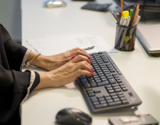 Business woman at the office typing on the keybaord|