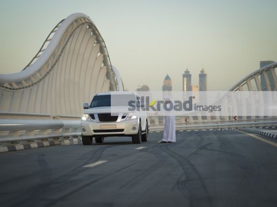 Arab man parked on the side of the road calling for help|