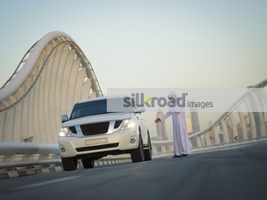 Arab man stopped on the side of the road calling for help|