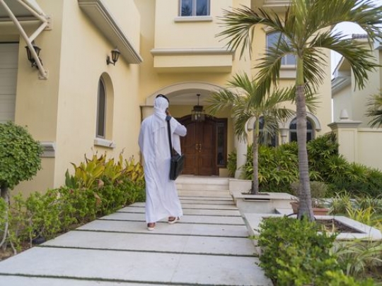 Arab man walking towards the house door|-