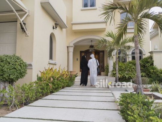 Middle Eastern couple walking towards the house|
