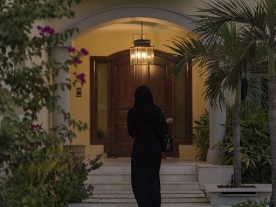 Arab woman walking towards her home|-