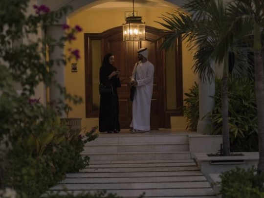 Arab man and woman standing infront of the house|-