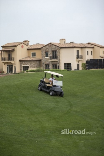 Middle Eastern man driving the Golf Cart around the resort|-