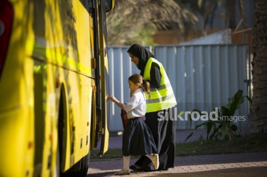 Supervisor and Young student walking together to the school bus|-