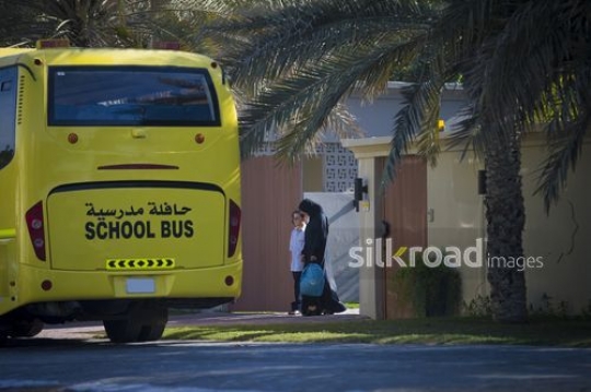 Middle Eastern mother walking her son to the school bus|-