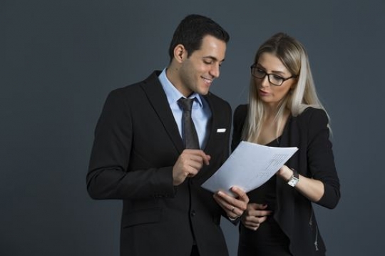 Medium shot of a business man and business woman talking to each other|