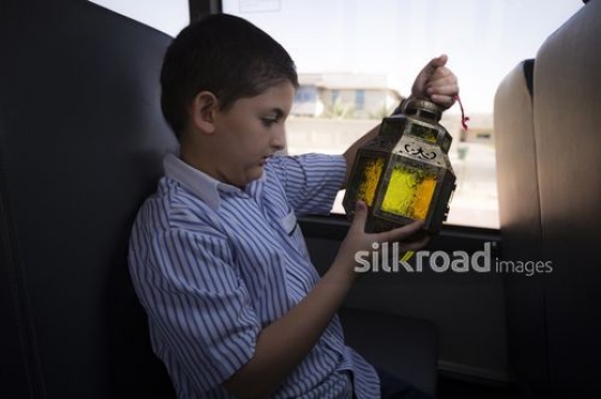 Young student carrying a Ramadan Lantern in his hand|-