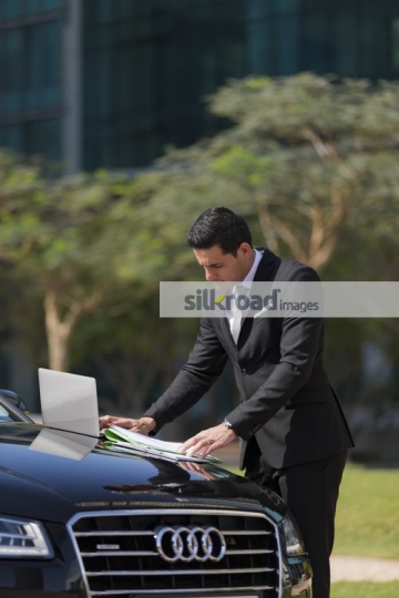 Arab Businessman working by his car |