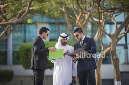 Middle Eastern Businessman talking to his employees outside |-