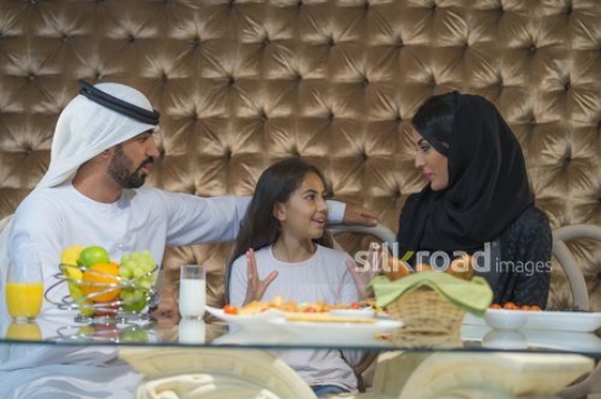 Arab man and woman sitting with the young girl|