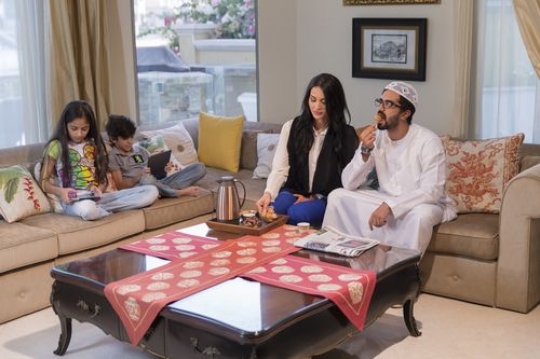 Arab parents sitting together while the kids are on their devices|-