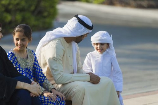 Middle eastern family sitting on the bench|-