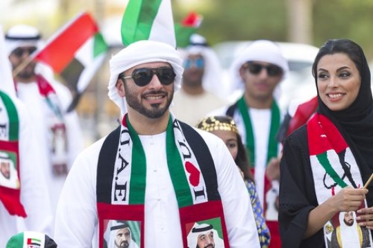 Arabian family at a parade celebrating National Day|