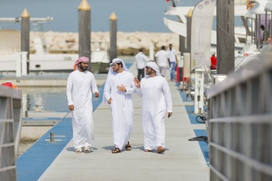 Three arab men walking towards the dock talking to each other|