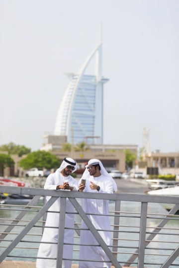 Arab men standing by the dock talking to each other|