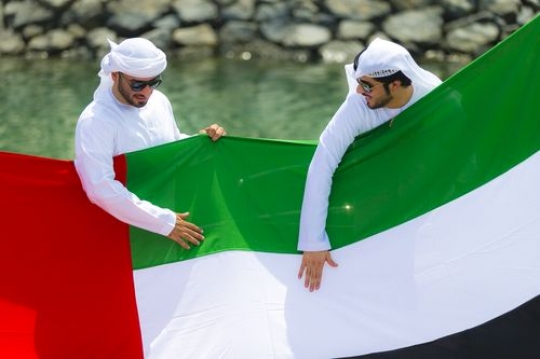 Arabian men representing their country while holding the UAE Flag|